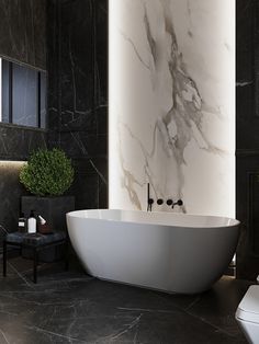 a large white bath tub sitting next to a toilet in a black and white bathroom