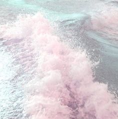 the back end of a boat traveling through water with pink foam on it's side