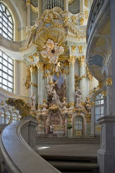 the interior of a church with gold and white decorations on the walls, pews and stairs