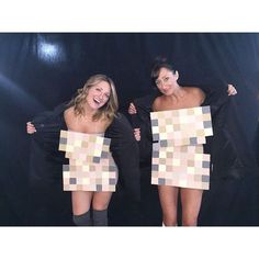 two women are posing with their arms around each other and holding up some paper squares