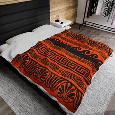 a bed with an orange and black bedspread