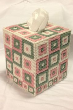 a tissue box made out of knitted squares with a white tissue in the middle