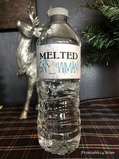 a bottle of water sitting on top of a table next to a christmas tree and reindeer