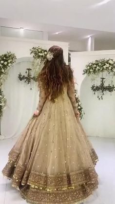 a woman standing in front of a mirror wearing a dress with gold sequins