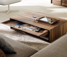 a coffee table with a tablet on it and some wine glasses in front of it