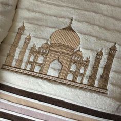 an embroidered towel with a tattered mosque on it's side and the word, i am not sure what this is