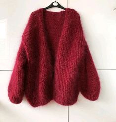 a red sweater hanging on a white wall