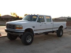 a white pick up truck parked in a parking lot next to a fire hydrant