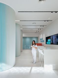 a woman is standing in the middle of a room with white walls and flooring