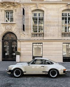 a white car parked in front of a building