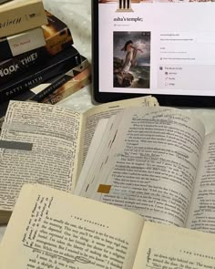 an open book sitting on top of a table next to a laptop computer and books