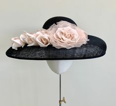 "A classically elegant navy blue wide brim straw hat, with a beautiful floral twist. This headpiece features a beautiful shell oyster pink duchesse satin pleated band around the crown. To complement the band, a matching oyster pink satin and organza rose sits in the centre, with a gorgeous cluster of five handmade silk rose buds trailing  along the brim. This hat measures 44cm from side to side, and 37cm front to back, and is made to a standard 22\" diameter. If you require a smaller fit, I am a Elegant Navy Hat For Evening, Handmade Flower Hats For Royal Ascot Evening, Elegant Hats With Handmade Flowers And Short Brim, Elegant Hats With Handmade Flowers For Spring, Elegant Spring Hats With Handmade Flowers, Elegant Fitted Hats With Handmade Flowers, Elegant Navy Hats With Curved Brim, Elegant Spring Hat With Handmade Flowers, Elegant Navy Hat With Curved Brim