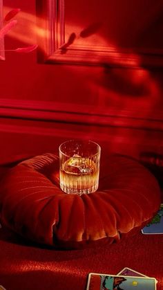 a glass sitting on top of a red cushion