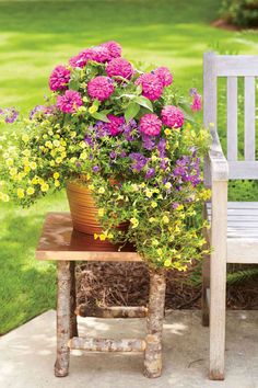 a white bench sitting next to a potted plant on top of a wooden table