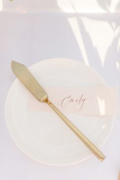 a white plate with a gold fork on it and a name tag that says craft