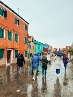 people walking down the street with umbrellas on a rainy day in venice, italy