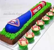 cupcakes are arranged in the shape of a baseball bat and dugout on a cake