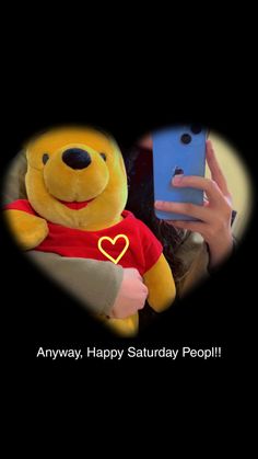 a person holding a cell phone with a winnie the pooh stuffed animal on it