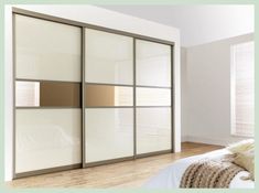 an image of a bedroom setting with white and brown closet doors in the middle of it