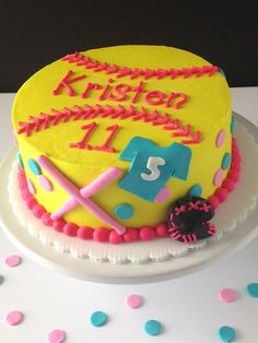 a birthday cake that is decorated with pink, blue and yellow icing