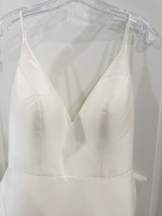 a white wedding dress hanging on a hanger