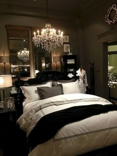 a bedroom with a chandelier hanging from the ceiling and a bed in front of it