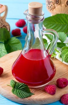 raspberry syrup in a glass bottle with fresh raspberries around it