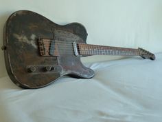 an old guitar sitting on top of a bed