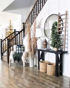 a living room filled with furniture next to a stair case and christmas tree on top of a table