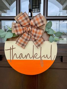 a wooden sign that says, thank you and has a bow on the front door