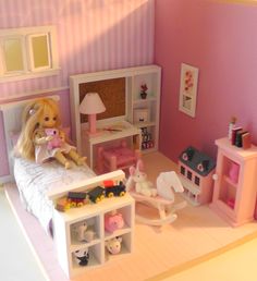 a doll house with a bed, desk and toy animals on the floor next to it