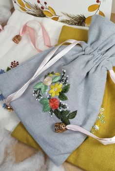 a handbag with flowers on it sitting on top of some other fabric materials