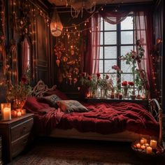 a bedroom decorated in red and gold with candles on the bed, roses hanging from the window