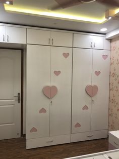 the closets are decorated with hearts and pink flowers on them, as well as white cupboards