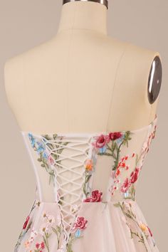 the back of a dress with flowers on it and laces at the neckline