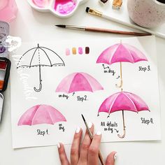 a person is drawing with watercolors on paper and an umbrella in the background