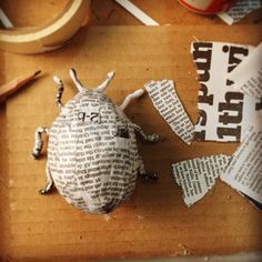 a paper mache beetle sitting on top of a wooden table