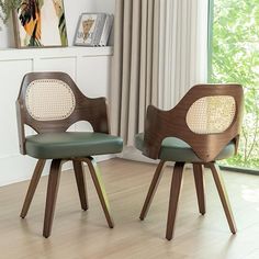 two wooden chairs sitting next to each other on top of a hard wood floor in front of a window