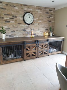 a clock mounted to the side of a brick wall next to a dog kennel