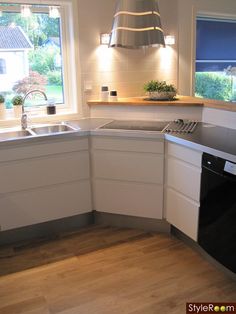 a kitchen with an oven, dishwasher, sink and window in the corner