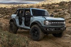 the new ford bronco pickup truck is driving on a dirt trail through rocky terrain