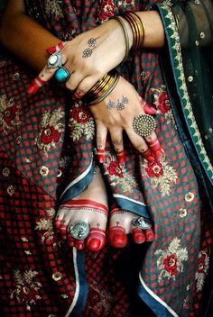 two hands with tattoos and rings on them