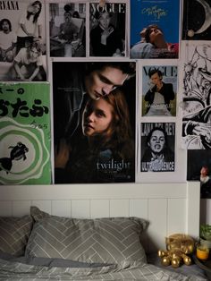 a bedroom with posters on the wall and a bed in front of it is shown