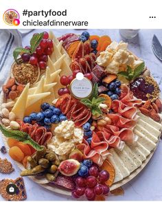 a platter filled with different types of cheeses and crackers on top of a table