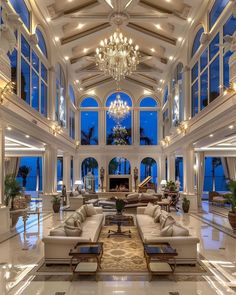 a large living room with high ceilings and chandeliers