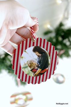 a hand holding a christmas ornament with a photo on it