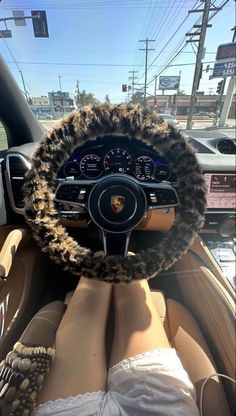 the interior of a car with a steering wheel covered in faux fur and leopard print