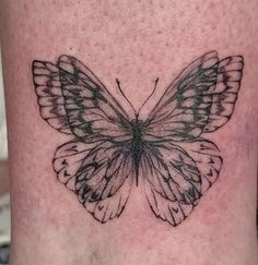 a black and white butterfly tattoo on the stomach