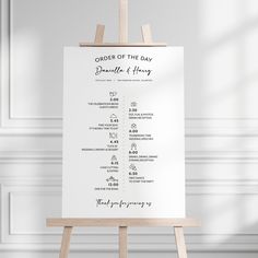 an order of the day sign sitting on top of a easel in front of a white wall