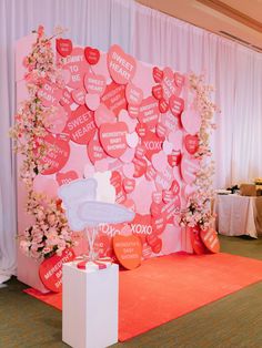 a pink backdrop with hearts and flowers on the wall for a wedding reception or special event